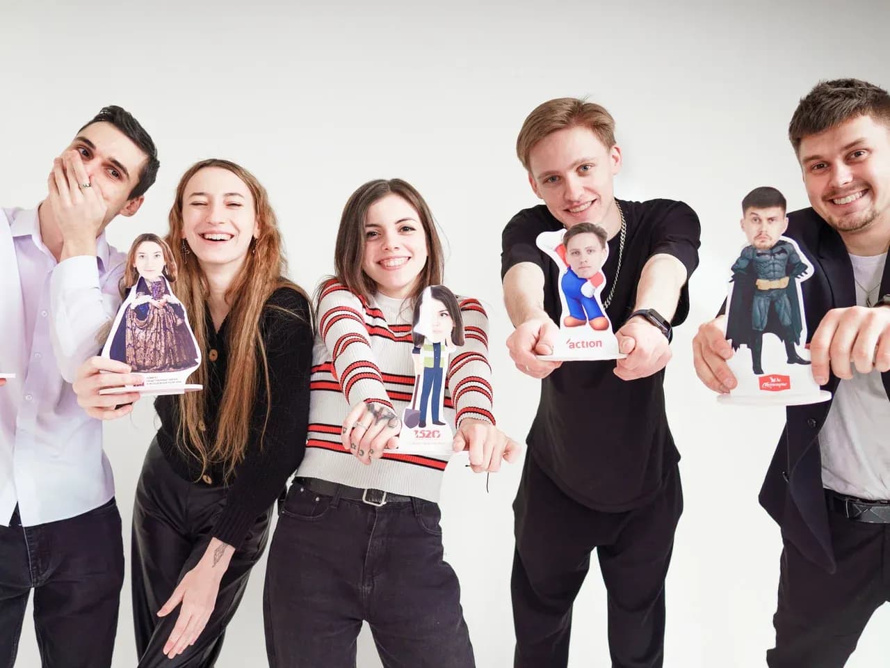 Гости держат фигурки Bubble Heads с большими головами на белом фоне