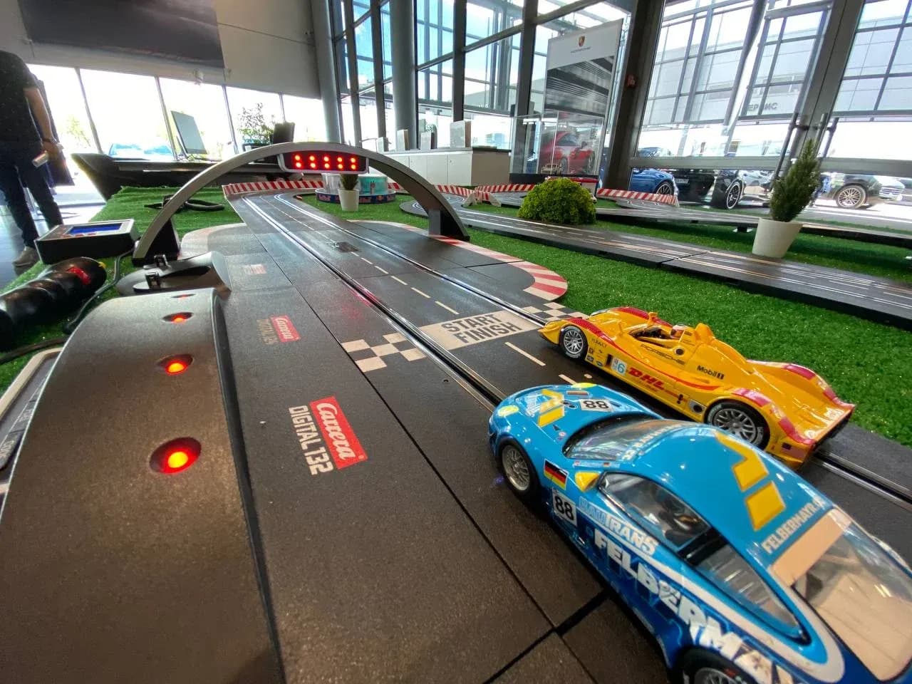 Трековые гонки slot-car: две машинки на трассе, вид с уровня трека