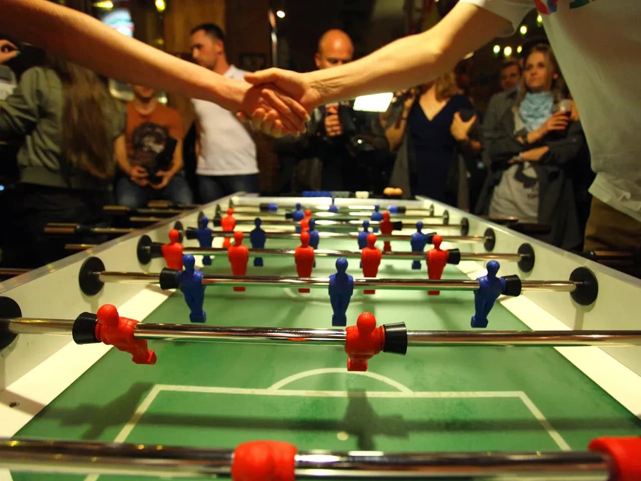 Кикер крупным планом: игровые фигурки и мяч на поле настольного футбола