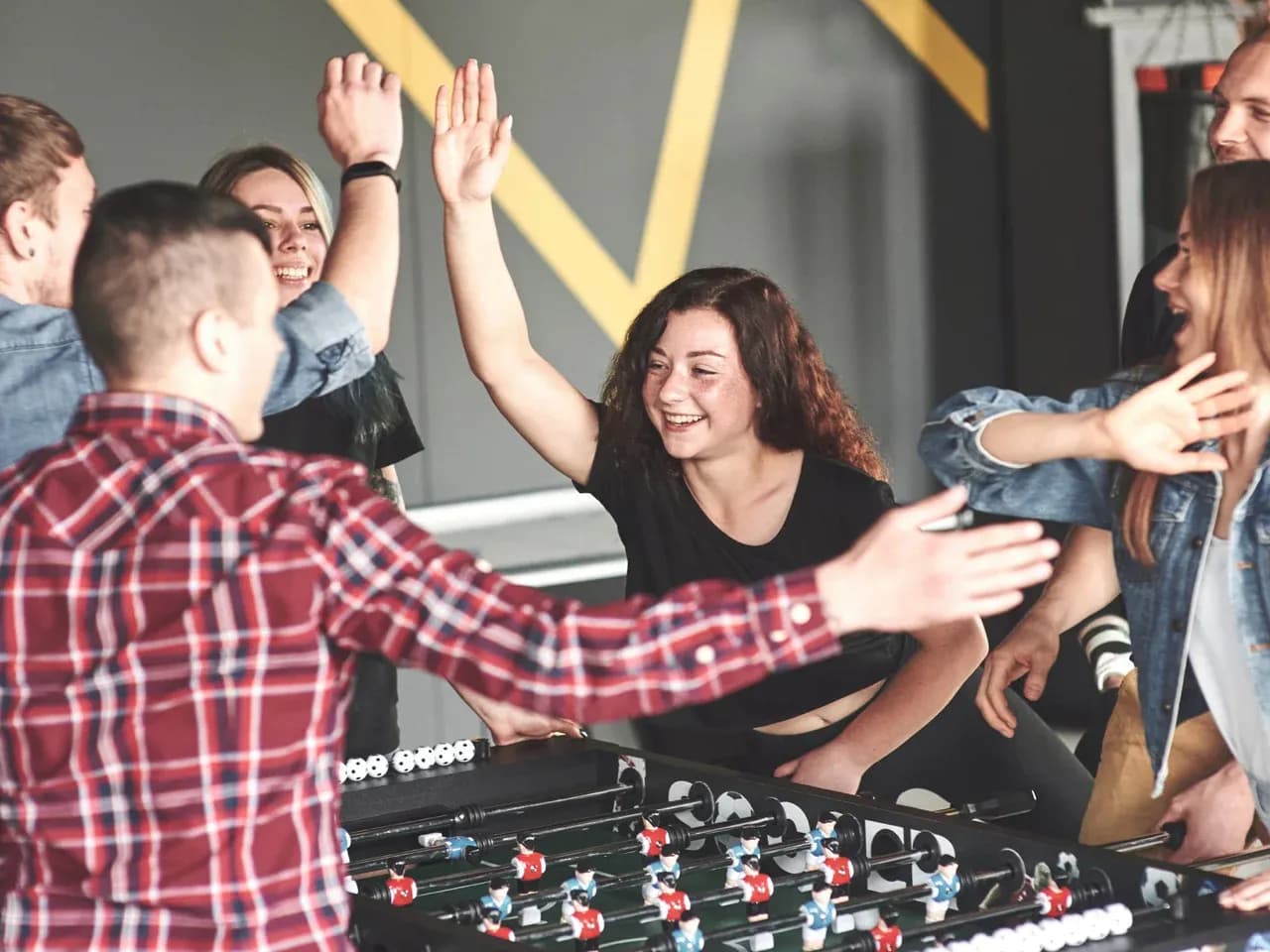 Кикер на мероприятии: гости играют в настольный футбол, вид сбоку