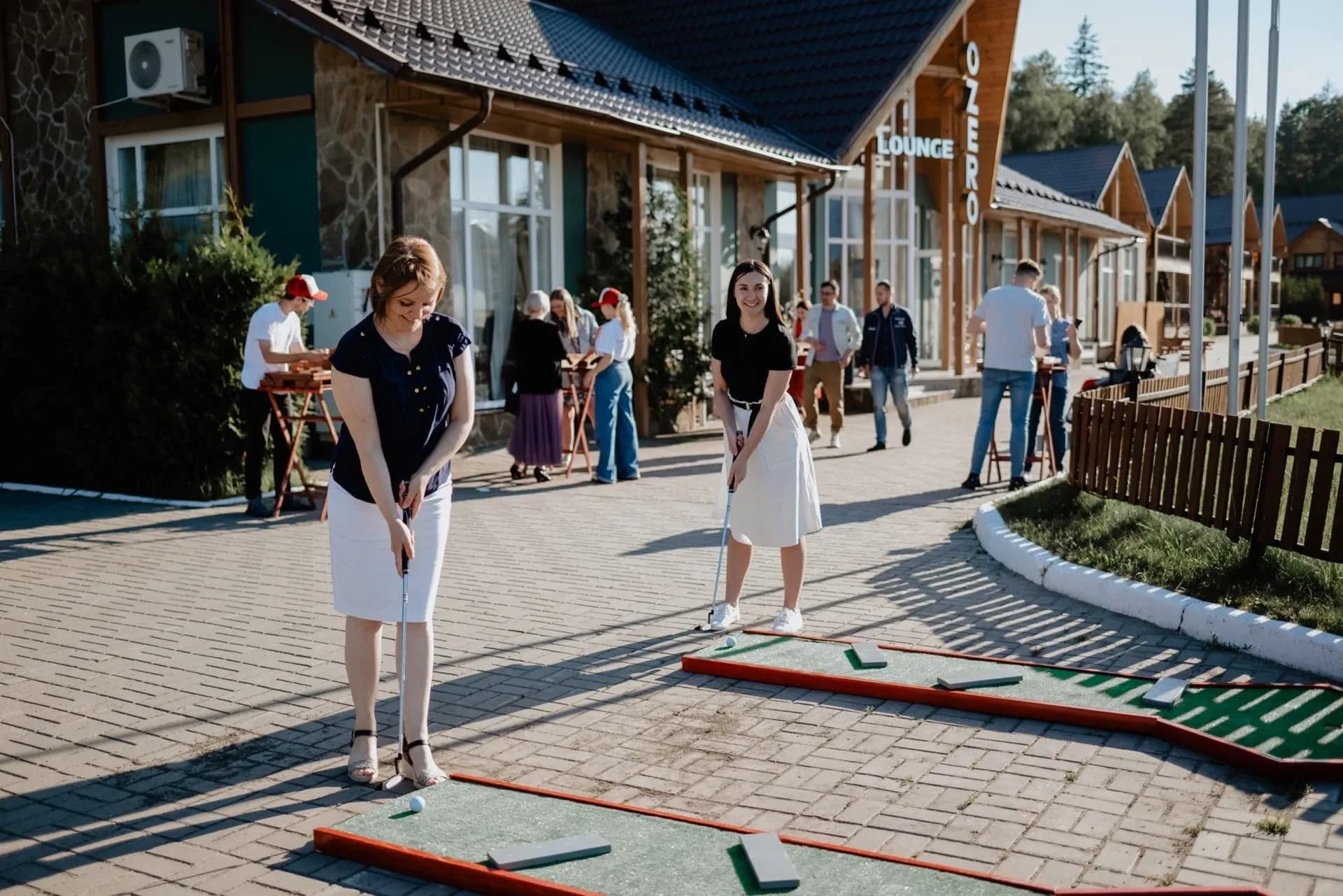 Мини гольф на мероприятии: гости играют на дорожках с клюшками и мячом
