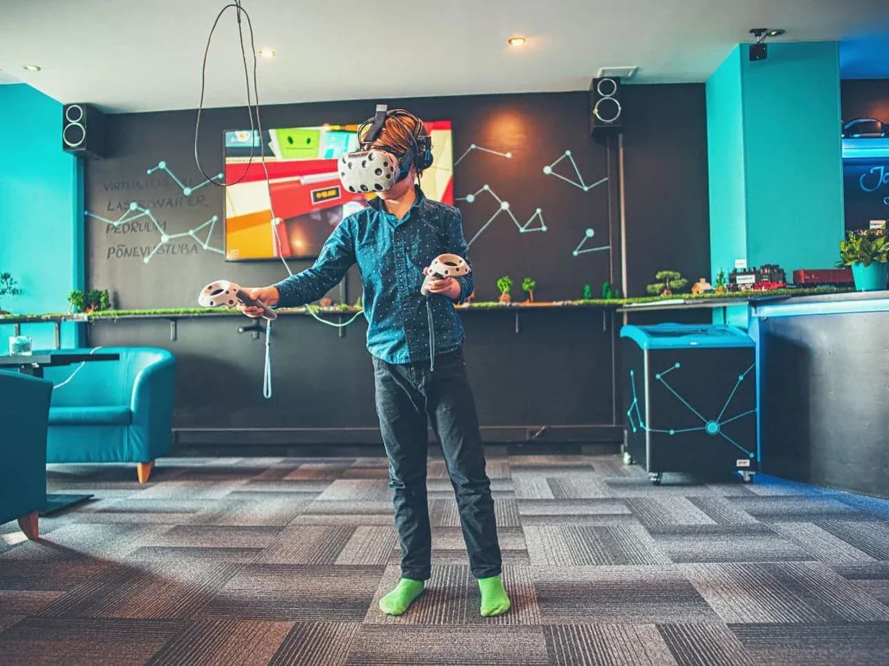 VR-игра в зале: гость в шлеме виртуальной реальности с контроллерами