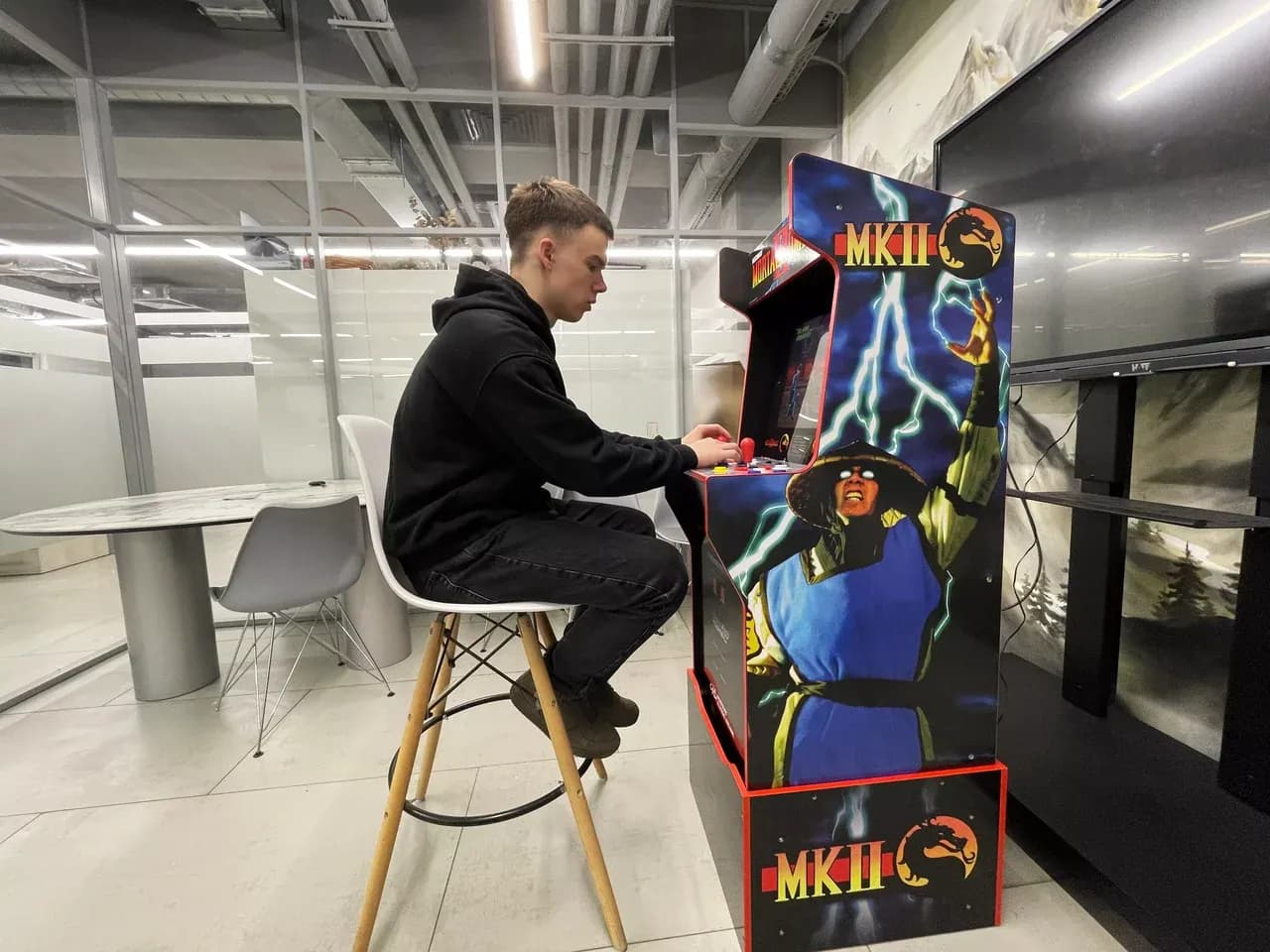 Гость играет в Mortal Kombat на аркадном автомате