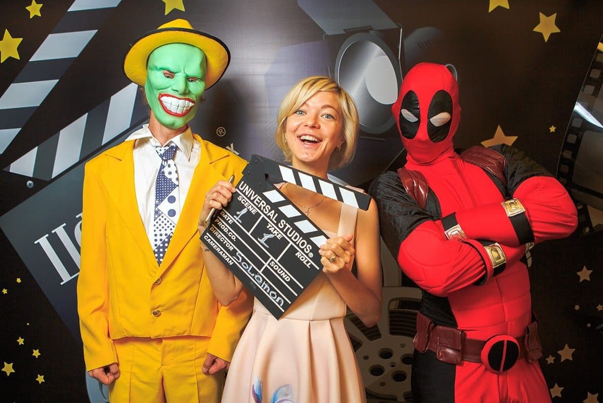 Девушка с аниматорами делает фото на фотобудку