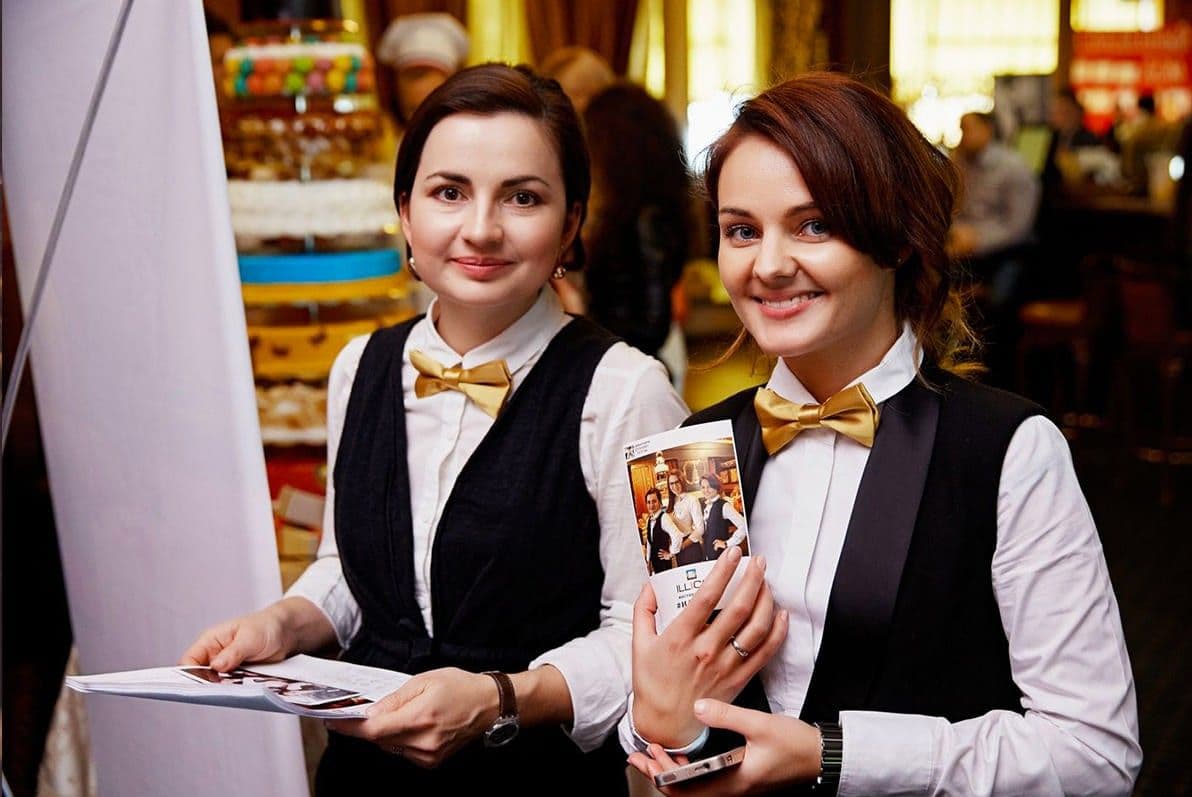 Гости держат в руках готовые фотокарточки из фотостойки